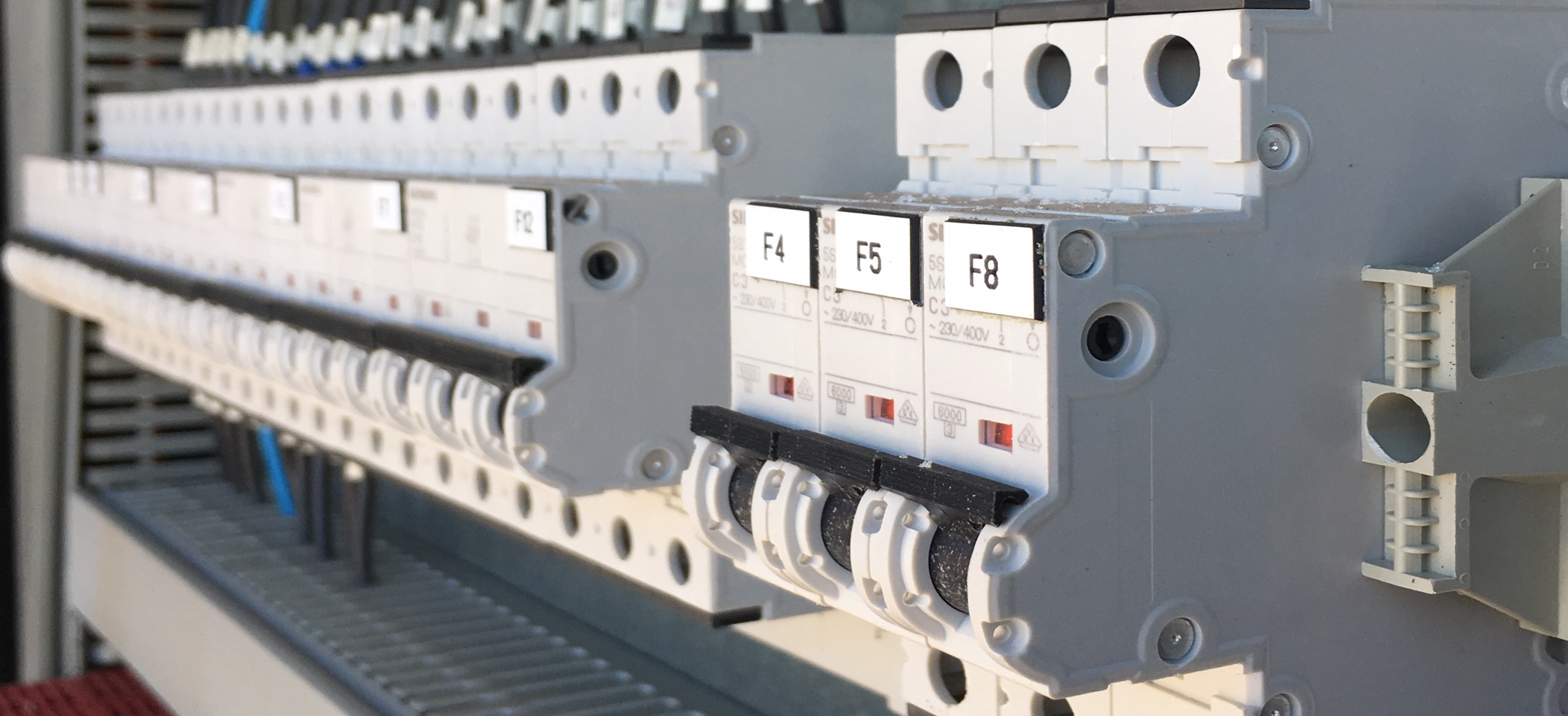 A photo of the inside of electrical cabinet showing a row of electrical devices